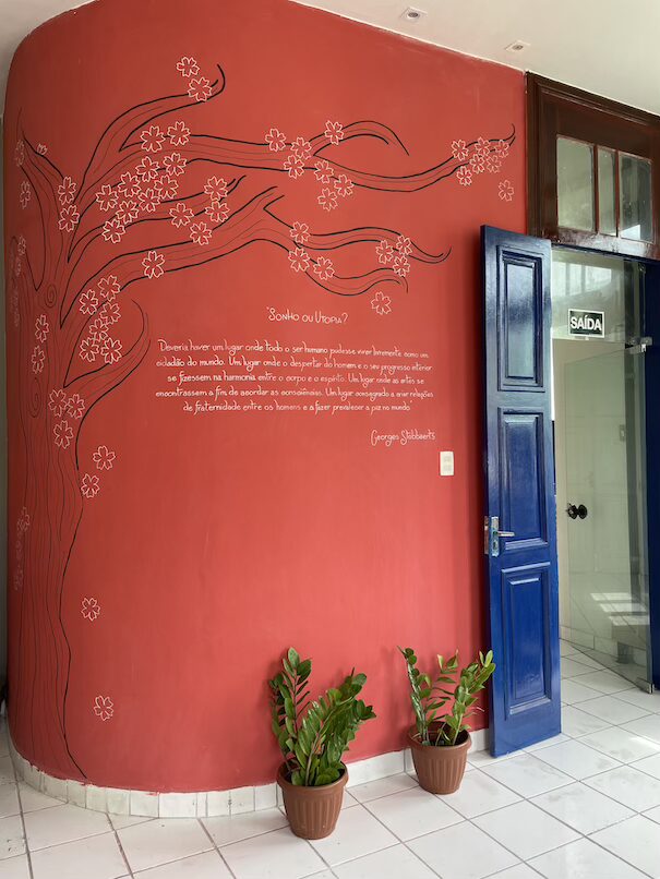 Parede com árvore de cerejeira e frase do mestre